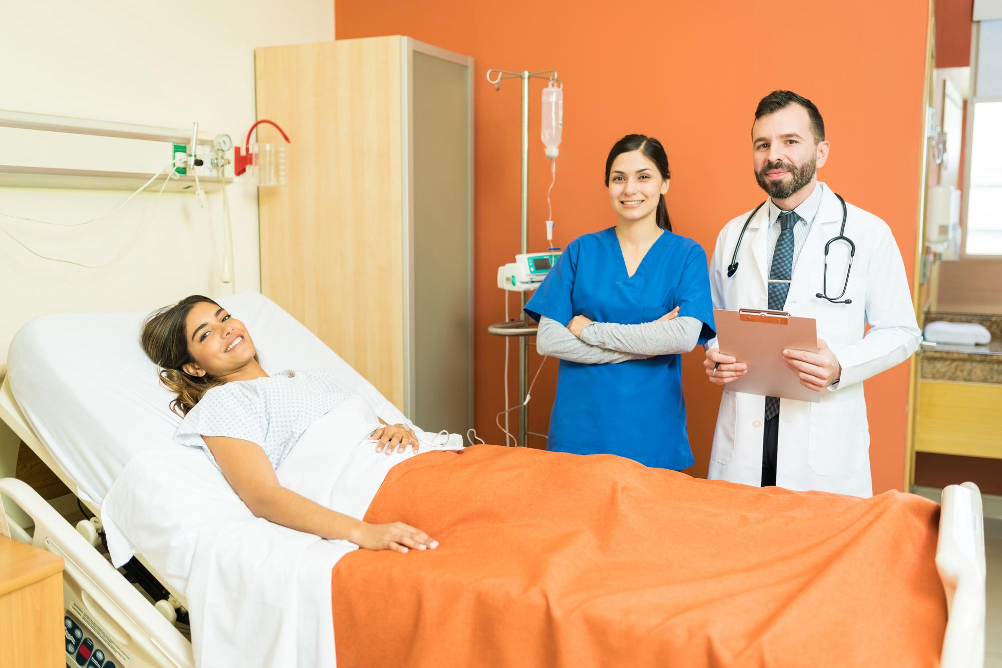 smiling-doctor-nurse-with-young-patient-hospital